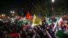 Para demonstran melambaikan bendera Iran dan Palestina saat demo di depan Kedutaan Besar Inggris di Teheran, Minggu, 14 April 2024, setelah Iran meluncurkan serangan drone dan misil ke Israel. (Foto: Atta Kenare/AFP)
