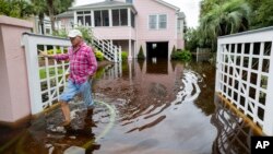 Robert Chesnut berjalan keluar memeriksa pekarangan rumahnya setelah banjir akibat Badai Tropis Debby, di kota Isle of Palms, South Carolina Kamis, 8 Agustus 2024. 