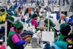 FILE - Garment employees work in a sewing section of the Snowtex Outerwear Ltd. factory in Savar, Bangladesh, Aug. 9, 2021.