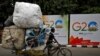 A man rides his trishaw past hoardings installed alongside a pavement ahead of the G20 Summit in New Delhi, Sept. 6, 2023. 