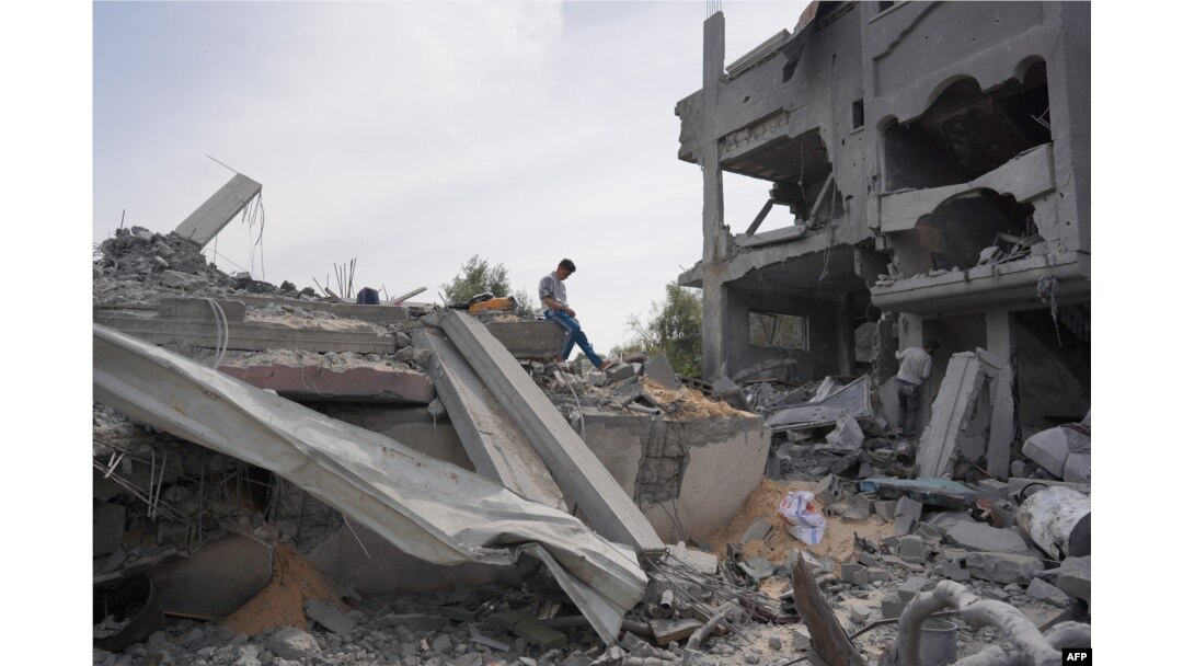 Seorang pemuda Palestina memeriksa puing-puing sebuah bangunan, setelah pengeboman Israel, di Kamp Maghazi untuk pengungsi Palestina di Jalur Gaza tengah. (Foto: AFP)