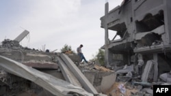 A Palestinian youth inspects the debris of a building, following Israeli bombardment, in the Maghazi camp for Palestinian refugees in the central Gaza Strip.