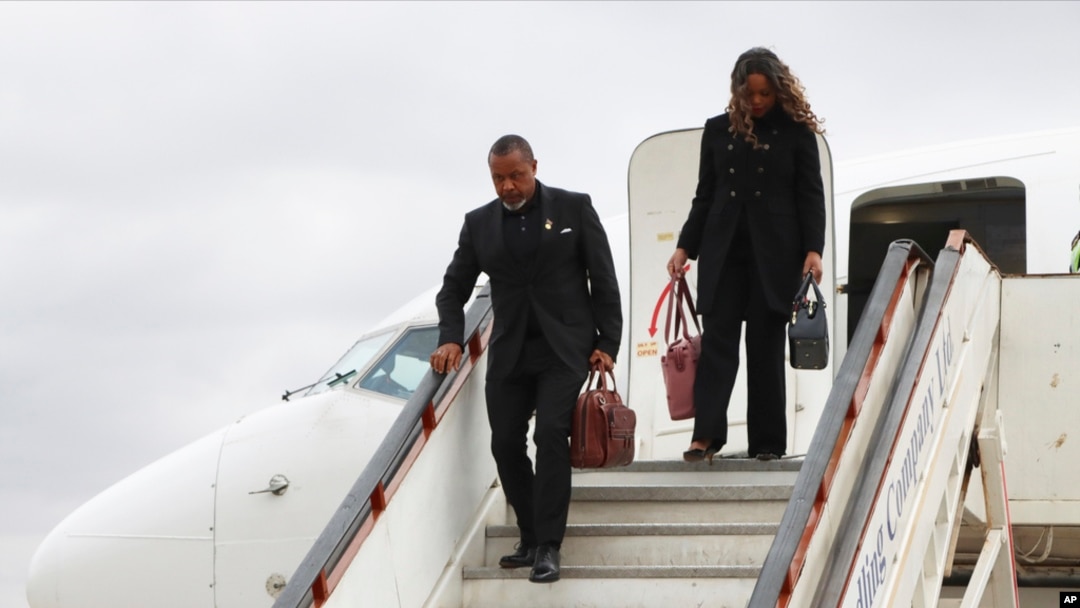 FILE - Malawi Vice President Saulos Chilima, left, and his wife, Mary, disembark from a plane upon his return from South Korea in Lillongwe, June 9, 2024. A military plane carrying Malawi's vice president and nine others went missing Monday, the president's office said. 