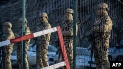 FILE - Azerbaijani servicemen stand guard at a checkpoint at the Lachin corridor, the Armenian-populated breakaway Nagorno-Karabakh region's only land link with Armenia, Dec. 27, 2022.