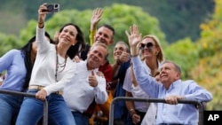 Opposition leader Maria Corina Machado takes a selfie with opposition presidential candidate Edmundo Gonzalez, right, while protesting election results declaring President Nicolas Maduro the winner in Caracas, Venezuela, July 30, 2024.