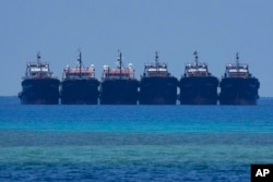 FILE - Six suspected Chinese militia ships lay side by side at the Philippine-claimed reef called Whitsun, at the South China Sea, April 22, 2023.