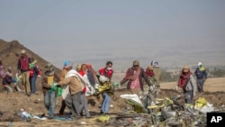Tim evakuasi bekerja di lokasi jatuhnya pesawat Boeing 737 Max 8 di dekat wilayah Bishoftu, di selatan Addis Ababa, Ethiopia, pada 11 Maret 2019. (Foto: AP/Mulugeta Ayene)