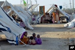 Anak-anak bermain di luar tenda mereka di kamp bantuan, di Jaffarabad, sebuah distrik di provinsi Baluchistan barat daya, Pakistan, Kamis, 29 September 2022. Hampir 3 juta anak di Pakistan mungkin kehilangan setidaknya satu semester karena kerusakan sekolah akibat banjir. (AP/Zahid Hussain)