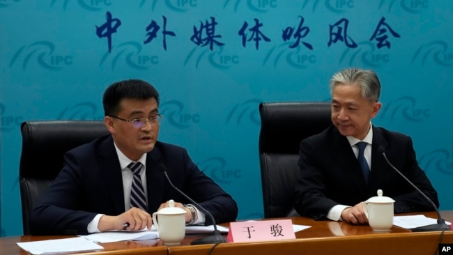 Deputy Director of Department of Eurasia of Ministry of Foreign Affairs Yu Jun, left, speaks with Chinese Foreign Ministry spokesperson Wang Wenbin after a news conference in Beijing, Wednesday, April 26, 2023. (AP Photo/Andy Wong)