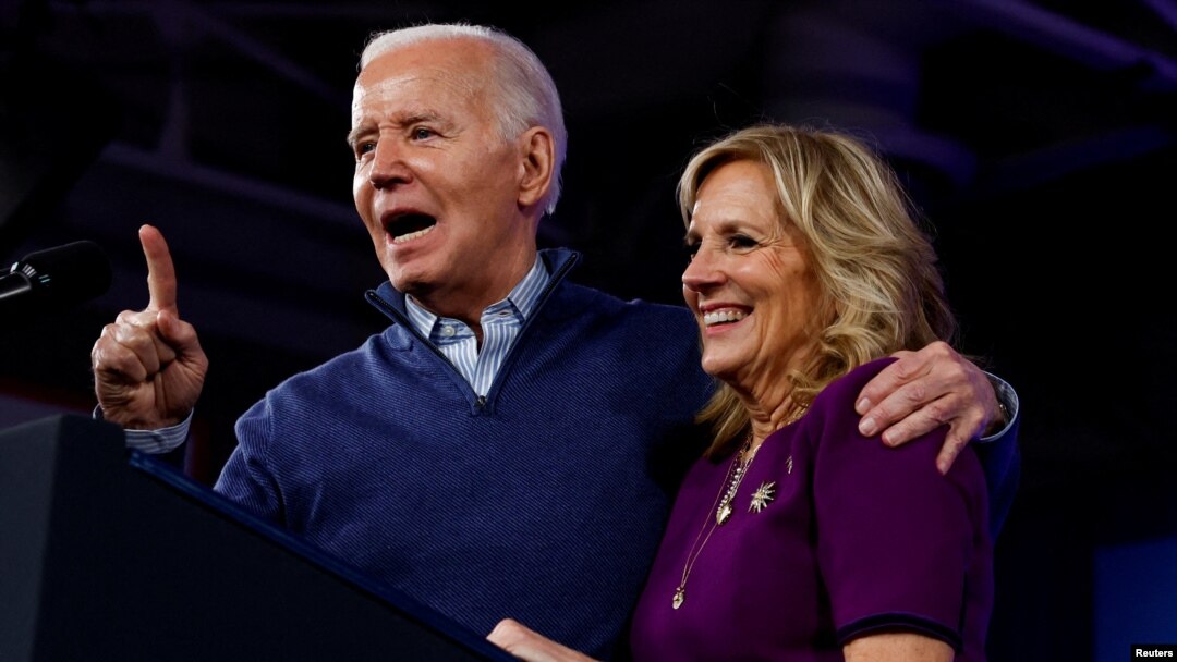 Foto Achiv: Prezidan Joe Biden salye yon moun pandan premye dam Jill Biden kanpe bo kote l, 8 Mas, 2024. 