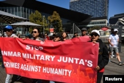 Orang-orang memegang spanduk dalam unjuk rasa komunitas Myanmar di Australia, menyerukan ASEAN agar tidak mendukung junta Myanmar, di luar KTT ASEAN-Australia, Melbourne, 4 Maret 2024. (Foto: Reuters)