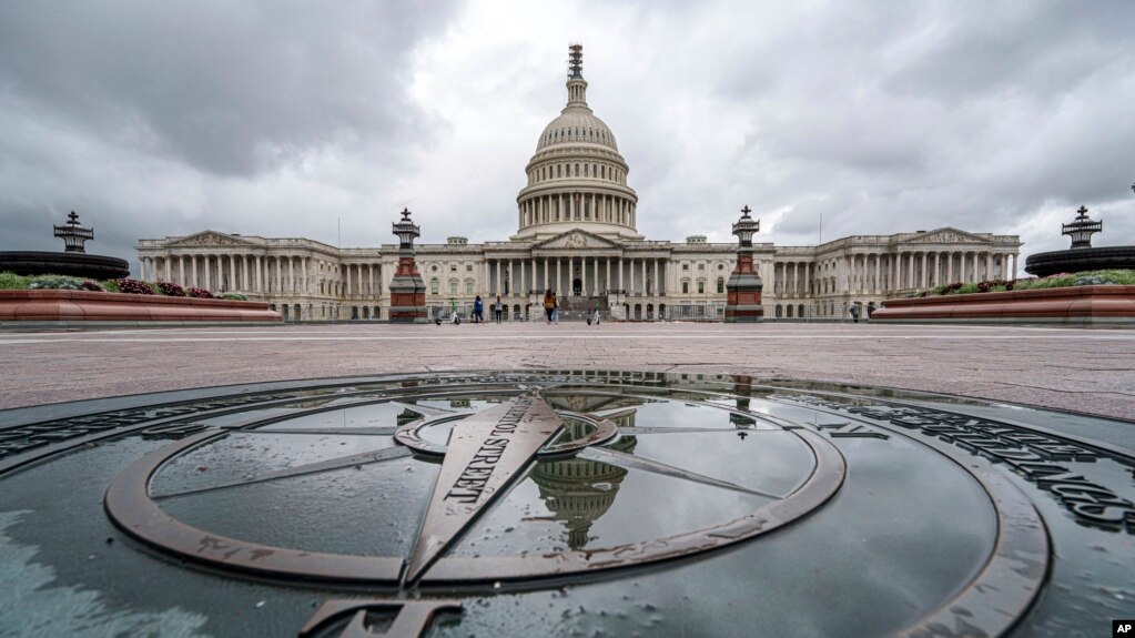 FILE - The U.S. Capitol Dome is reflected in a rain puddle on the compass star on the east side of the building, Sept. 24, 2023.