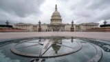 FILE - The US Capitol Dome is reflected in a rain puddle on the compass star on the east side of the building, Sept. 24, 2023.