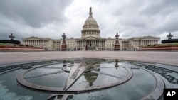 La cúpula del Capitolio de Estados Unidos se refleja en un charco de lluvia en la estrella de la brújula del lado este del edificio, el 24 de septiembre de 2023.