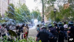 Police officers set off a smoke bomb in order to disperse a crowd, Aug. 4, 2023, in New York's Union Square.