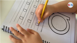 Un niño venezolano hace su tarea de caligrafía.