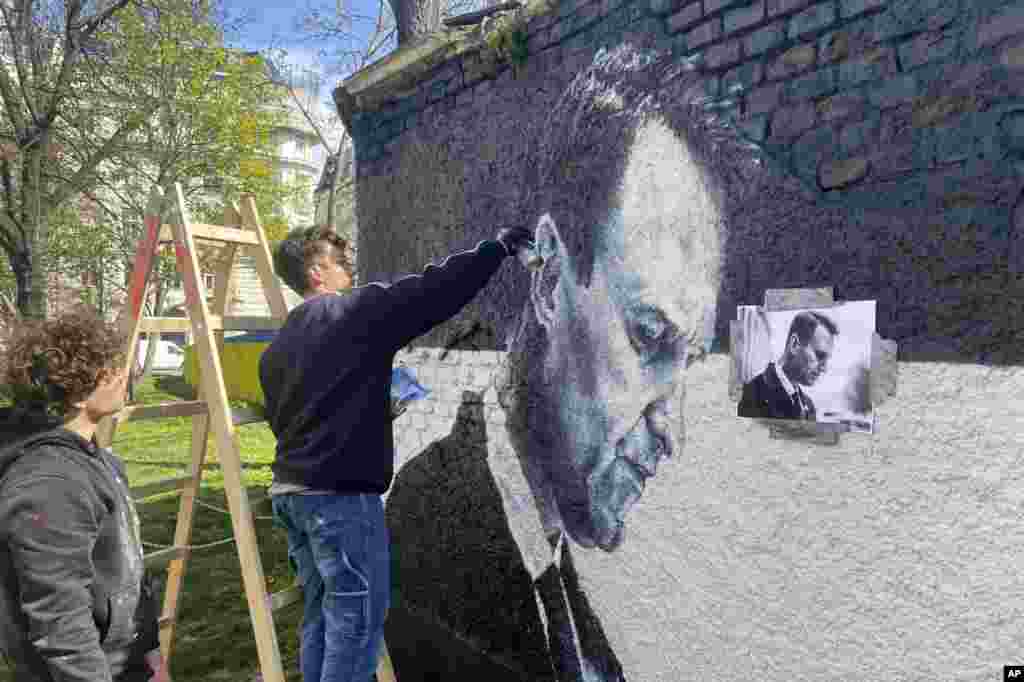 Duo artis grafiti Austria, Joel Gamnou, melukis gambar mendiang pemimpin oposisi Rusia Alexei Navalny di dinding di Wina, Austria, Rabu, 27 Maret 2024. (Foto:&nbsp;Philipp-Moritz Jenne/AP Photo)