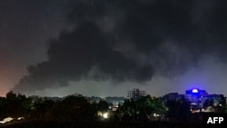 Smoke rises above buildings in Khartoum on May 19, 2023, as violence between two rival Sudanese generals continues.