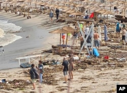 People observe the damage on the beach, after a storm, in Arapya, Bulgaria, Sept. 5, 2023.
