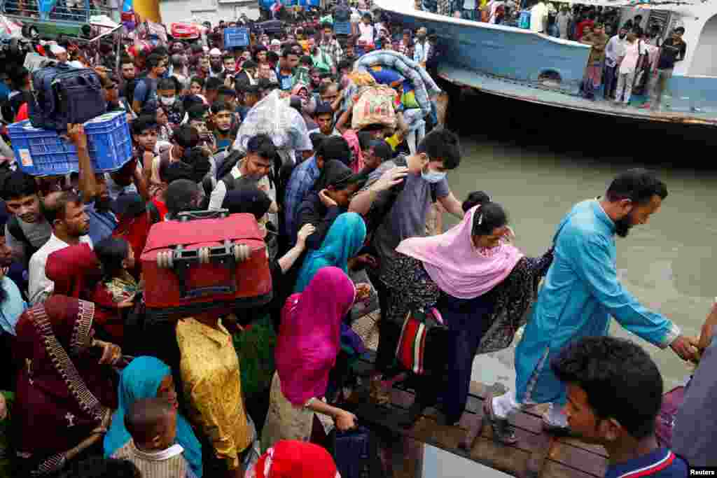 Thousands of people rush to board overcrowded boats at the Sadarghat Ferry Terminal as they leave to celebrate Eid-al Adha with their families, in Dhaka, Bangladesh.