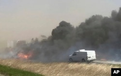 Smoke billows after a crash involving at least 20 vehicles shut down a highway in Illinois, Monday, May 1, 2023.