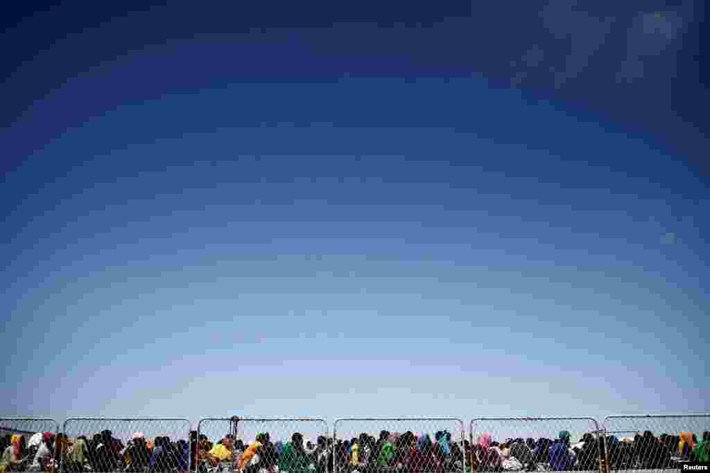 Migrants are seen on the deck of the military ship Cassiopea to be transferred to the mainland, on the Sicilian island of Lampedusa, Italy.