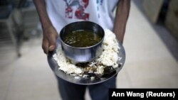 (FILE) A patient carries dinner in a medical center in Burma.