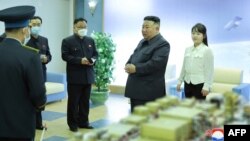 မြောက်ကိုရီးယား အာကာသအေဂျင်စီဌာနမှာ ကြည့်ရှုစစ်ဆေးနေတဲ့ ခေါင်းဆောင် ကင်ဂျုံအွန်း (Kim Jong Un) (ဝဲ) နဲ့ သမီး ဂျွန်အဲ (ယာ) တို့ကိုတွေ့ရစဉ် (ဧပြီ ၁၉ ၊ ၂၀၂၃)