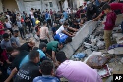 Palestinians look for survivors after Israeli airstrikes in Khan Younis, Gaza Strip, Oct. 16, 2023.