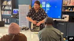 In this undated photo, Richie Hull, a lead instructor at the Connecticut-based group CfAL for Digital Inclusion, teaches participates how to take a computer apart and put it back together again. (Rose Servetnick/CfAL for Digital Inclusion via AP)