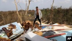 FILE - Jose Trinidad walks on what's left of his home in Montebello, Puerto Rico, in the aftermath of Hurricane Maria, Sept. 26, 2017.