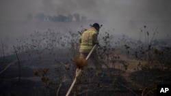 Пожарный работает над тушением пожара после нападения ливанской группировки «Хезболла» на контролируемые Израилем Голанские высоты, 4 июля 2024 года.