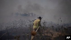 Vatrogasac radi na gašenju požara nakon napada libanske Hezbolah grupe na Golanskoj visoravni koju kontroliše Izrael, 4. jula 2024.