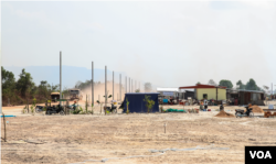 A truck travels on an unpaved road, passing a few homes still under contruction at Run Ta Ek development area, in Banteay Srei district, Siem Reap province, on Feb. 12, 2023. (Ten Soksreinith/VOA Khmer)