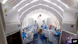 FILE - Staffers work in an inflatable COVID-19 testing lab provided by China's BGI Genomics in Beijing, June 23, 2020. China strongly objected March 3, 2023, after BGI Group and 17 others were hit with curbs on access to U.S. technology. (Xinhua via AP)
