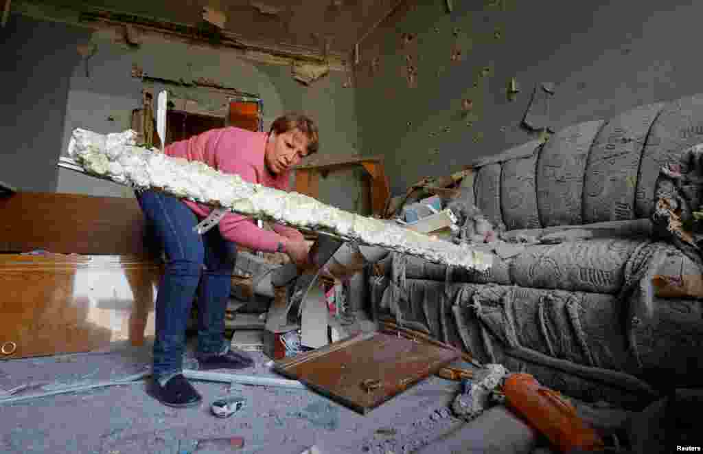 Valentina Makukha, 60, memeriksa kerusakan apartemennya akibat tembakan artileri baru-baru ini, yang oleh pejabat setempat dan penduduk disebut sebagai serangan militer Ukraina di kota Donetsk, wilayah Ukraina yang dikuasai Rusia. (Reuters)&nbsp;