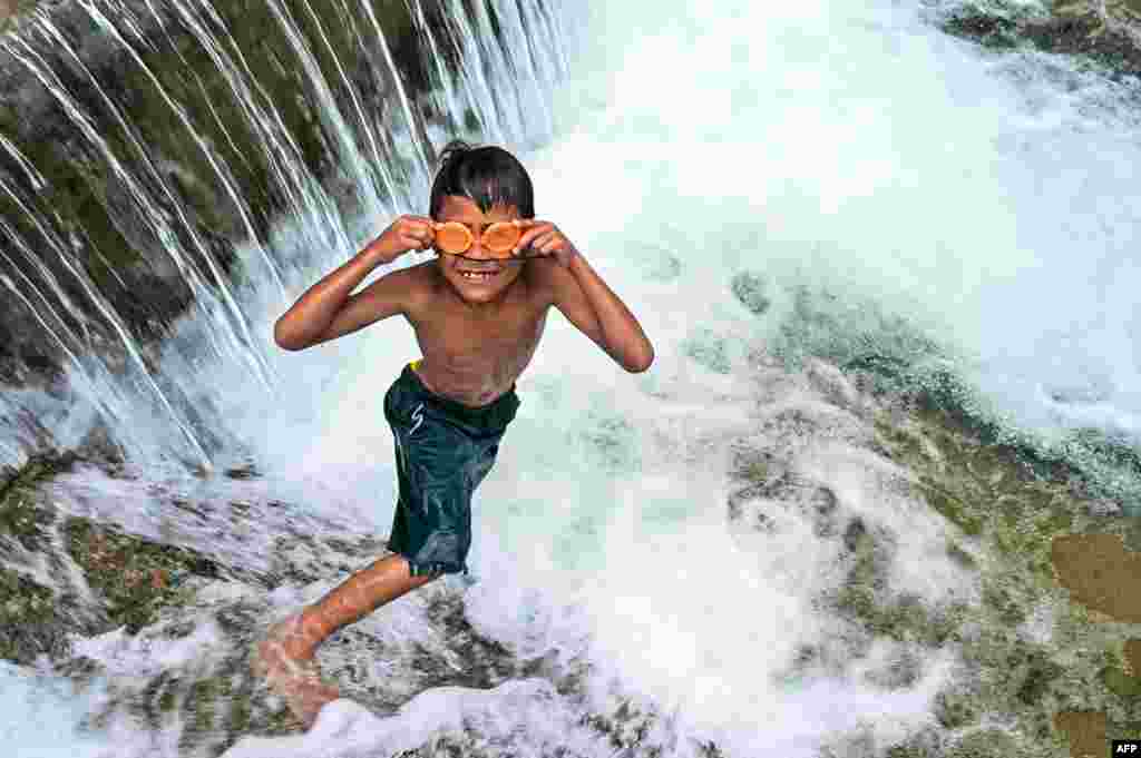 A child puts his swimming goggles on before jumping in a public pool of spring water in Japakeh, Indonesia&#39;s Aceh province during World Water Day. (Photo by CHAIDEER MAHYUDDIN / AFP)