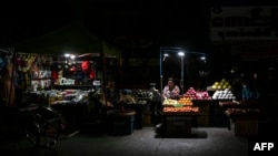 ရန်ကုန်မြို့မှာ မီးပျက်အချိန်အတွင်း ဈေးရောင်းနေတဲ့ ညဈေးသည်တချို့ကိုတွေ့ရစဉ် (မတ် ၃၊ ၂၀၂၂)
