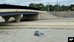 A vehicle is stranded in high waters on a flooded highway in Houston, on July 8, 2024, after Beryl came ashore in Texas as a hurricane and dumped heavy rains along the coast.