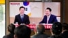 People watch a TV screen showing South Korean President Yoon Suk Yeol, right, meeting with main opposition Democratic Party leader Lee Jae-myung, during a news program at the Seoul Railway Station in Seoul, April 29, 2024. 