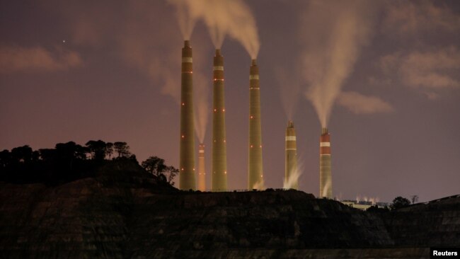 FILE - Smoke and steam billows from the coal-fired power plant owned by Indonesia Power, next to an area for Java 9 and 10 Coal-Fired Steam Power Plant Project in Suralaya, Banten province, Indonesia, July 11, 2020.