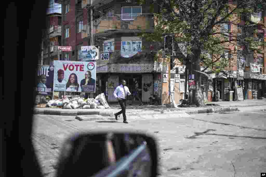 A man crosses an empty street that is usually very busy as people wait for the results of the presidential elections, in Lagos, Nigeria.