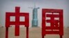 The Shenzhou-16 spacecraft sits atop a Long March rocket covered on a launch pad near characters reading "China" at the Jiuquan Satellite Launch Center in northwest China, May 29, 2023.