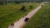 Migrantes caminan por un sendero después de cruzar el Río Grande en la frontera entre Estados Unidos y México, el jueves 11 de mayo de 2023, en Brownsville, Texas.