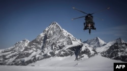 FILE - A helicopter of the Swiss Air Force flies above the Tete Blanche high altitude pass in the Swiss Alps, April 14, 2022. A major search operation is currently underway in the Swiss Alps to find six ski hikers missing since March 9, 2024.