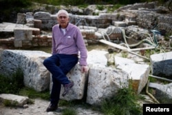 FILE - Former garbage man and amateur local historian Stefano Petrini poses for a photo at the ruins of an ancient spa where around 20 Etruscan and Roman bronze statues were discovered in San Casciano dei Bagni, a hilltop village in southern Tuscany still home to popular thermal baths, Italy, May 29, 2023. (REUTERS/Guglielmo Mangiapane)