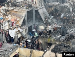 People search through the rubble of damaged buildings following an Israeli air strike on Palestinian houses, amid the ongoing conflict between Israel and the Palestinian Islamist group Hamas, in Rafah in the southern Gaza Strip, Dec. 12, 2023.