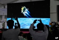 خبرنگاران از پخش زنده فرود چاندرایان-۳ بر سطح ماه فیلمبرداری می‌کنند