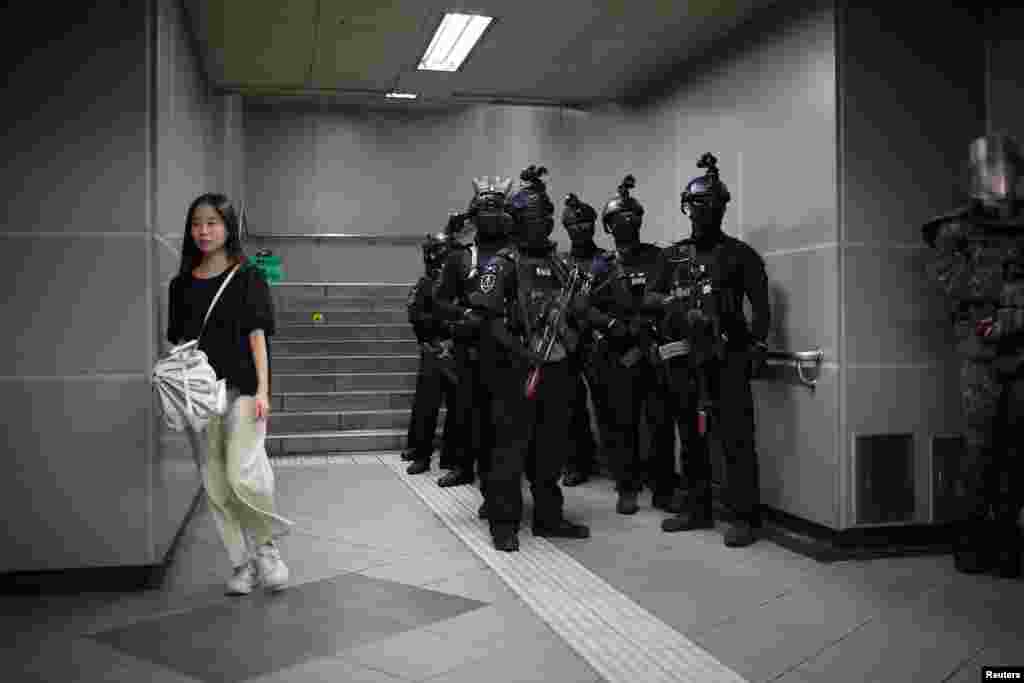 A woman walks past South Korean soldiers taking part in an anti-terror drill as part of the annual Ulchi Freedom Shield joint military exercise between South Korea and U.S., at a subway station in Seoul.