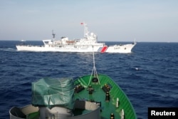 FILE - A ship of the Chinese coast guard is seen near a ship of the Vietnam marine guard, at bottom, in the South China Sea, about 210 km offshore from Vietnam, May 14, 2014.